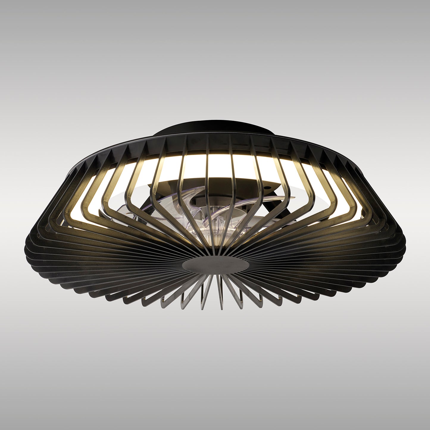 A close-up of Ceiling Fans UK's Himalaya Mini Black Ceiling Fan with Light, showcasing its modern LED Round Ceiling Light featuring a circular, radial design. The black, slatted frame encases the illuminated central bulb and 30W DC reversible fan, creating a geometric pattern. The background transitions in a plain gradient from light gray to white.