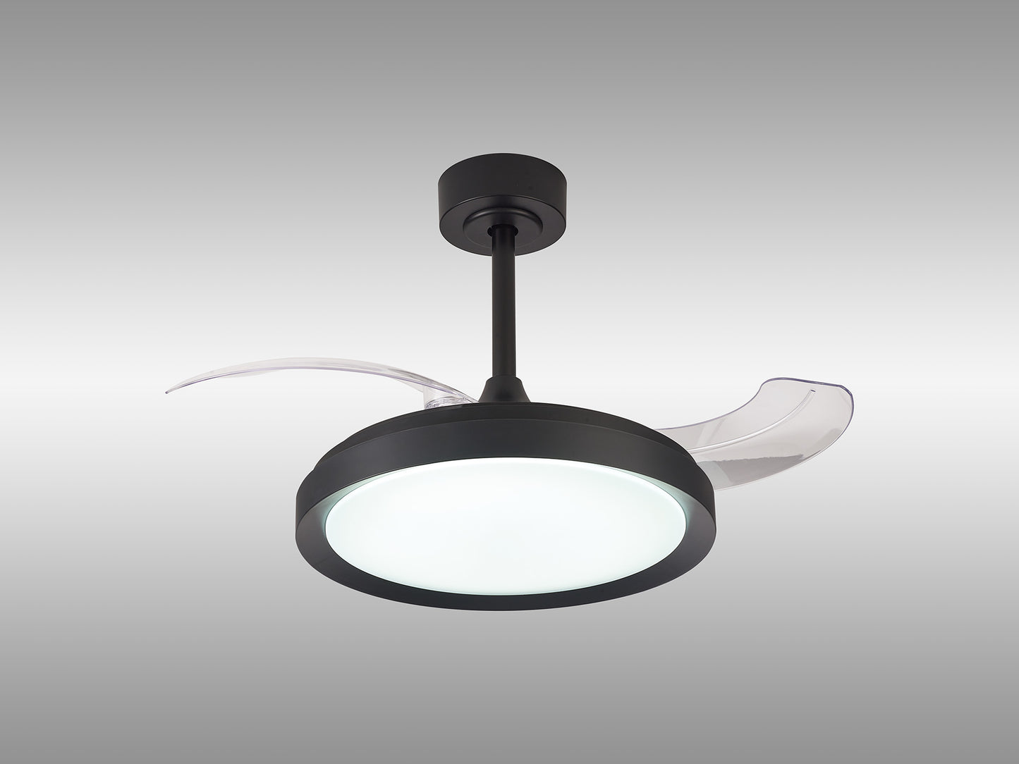 Introducing the Mistral Mini Black Ceiling Fan with Light by Ceiling Fans UK, a modern marvel featuring a sleek black cylindrical rod, a 40W dimmable LED light at its center, and three transparent, slightly curved blades. This stylish fan even comes with a convenient remote control and is backed by a 5-year warranty. The setup is complemented by a gradient of light gray in the background.