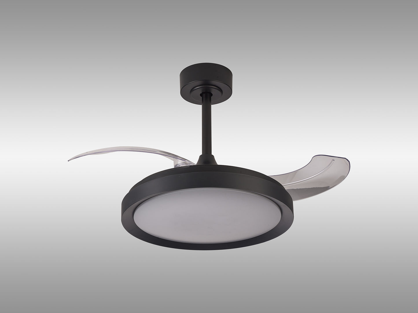 A contemporary Mistral Mini Black Ceiling Fan by Ceiling Fans UK, featuring a smooth matte black finish with a 40W dimmable LED centerpiece and transparent curved blades. The fan is mounted to the ceiling via a short cylindrical rod and includes a remote control for convenient operation. Set against a sleek gradient background transitioning from gray to white, this product also comes with a 5-year warranty.