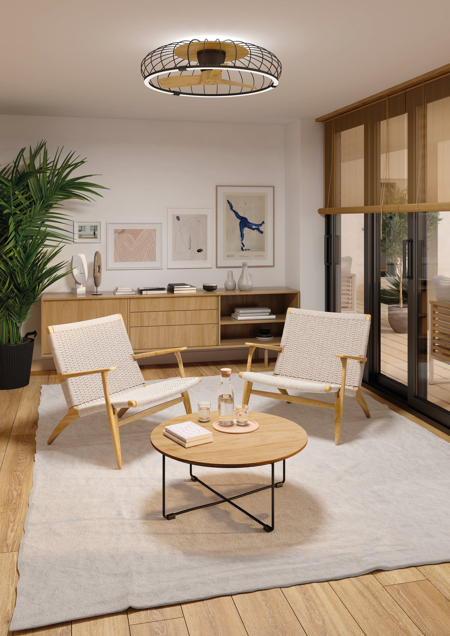 A cozy modern living room with woven chairs, a round wood coffee table, neutral decor, bamboo blinds, sunlight, and the Ceiling Fans UK MANTRA M7808 Nature Black/Beech 79cm LED dimmable ceiling fan with reversible 30W DC motor and smart controls.