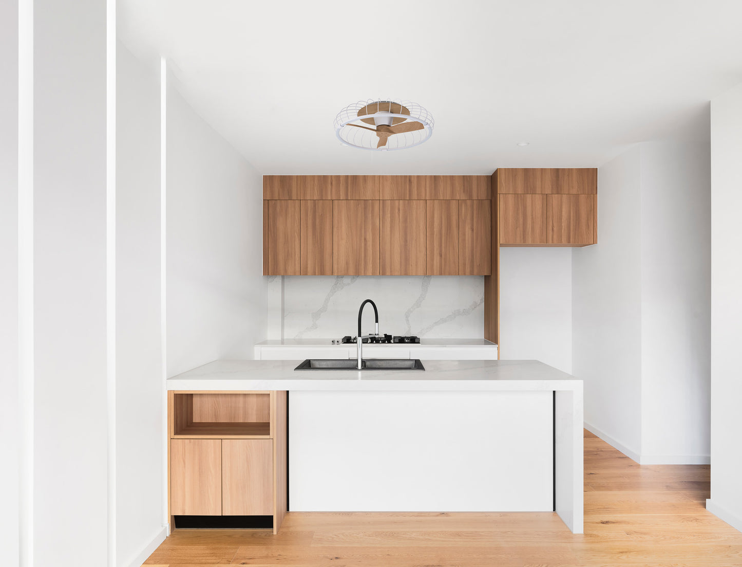 Minimalist kitchen with light wood cabinets, white countertops, and marble backsplash. The Ceiling Fans UK MANTRA M7809 Nature White/Beech 79cm ceiling fan with 75W dimmable LED light adds a sleek touch above the island; features remote and app control.