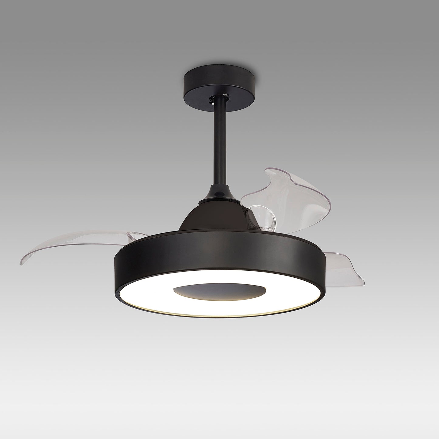 The Coin Black Ceiling Fan by Ceiling Fans UK is a modern fixture with translucent blades and a sleek black circular housing. This reversible fan hangs from the ceiling via a short black rod and features clear blades that enhance the central housing. The built-in 60W LED dimmable light brightens up any room, while the 30W DC reversible fan can be controlled via remote and app. It comes with a 5-year warranty, all set against a plain gradient gray background.