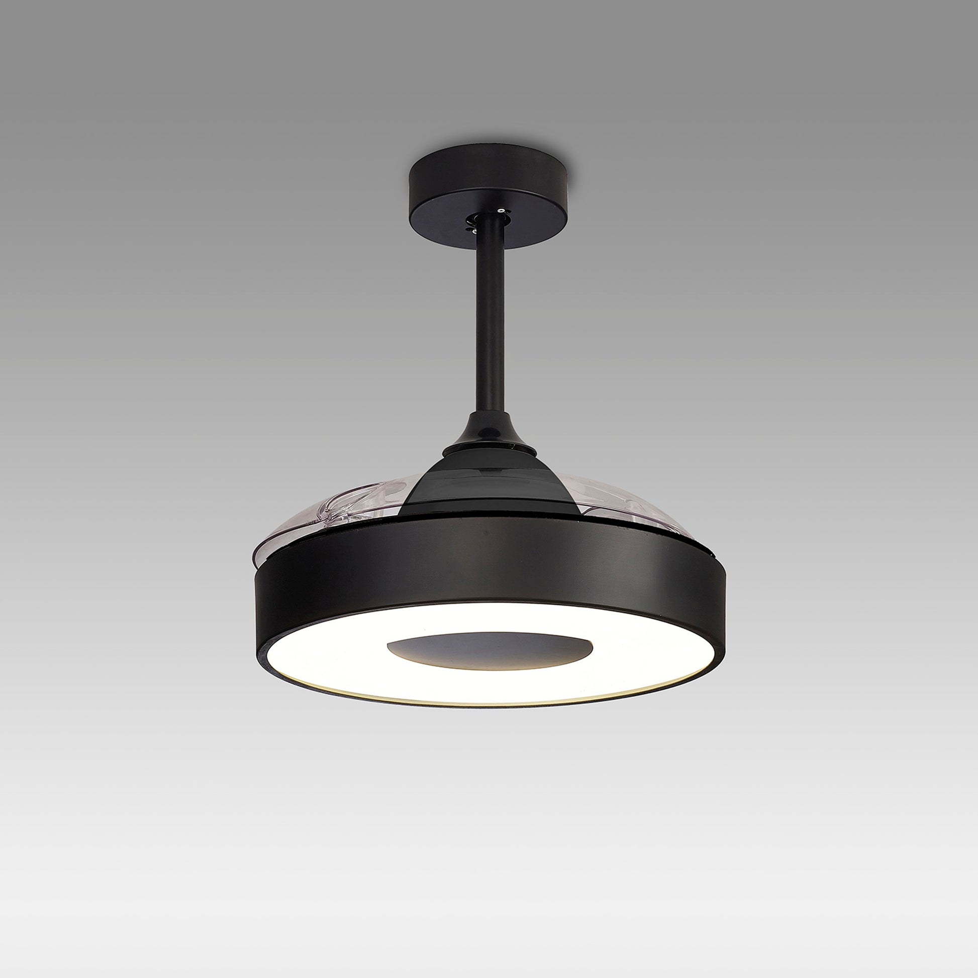 A Coin Black Ceiling Fan with light from Ceiling Fans UK is displayed against a plain gray background. The fixture boasts a matte black finish, a round, flat design, and includes an LED dimmable light that emits a soft white glow. It is suspended from a short rod connected to a circular ceiling mount. Additionally, this modern piece features a built-in 30W DC reversible fan and comes with remote and app control, backed by a 5-year warranty.