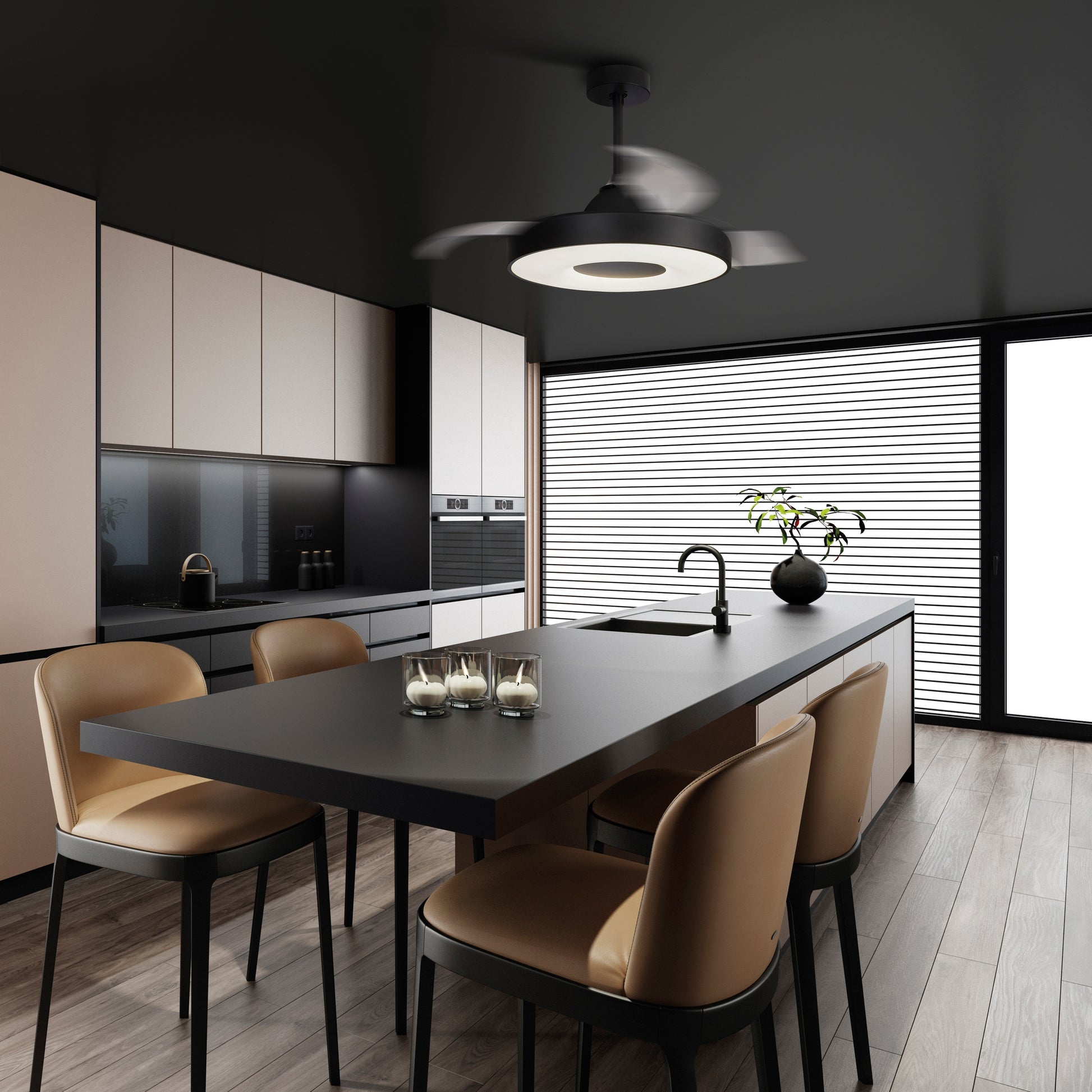 A modern kitchen features sleek black countertops, beige cabinets, and a central island with high-back beige chairs. Hanging above the island is a Ceiling Fans UK Coin Black Ceiling Fan with an integrated 60W LED dimmable light and a built-in 30W DC reversible fan, controllable via remote or app and backed by a 5-year warranty. The room is illuminated by large horizontal window blinds that allow natural light to flood in.