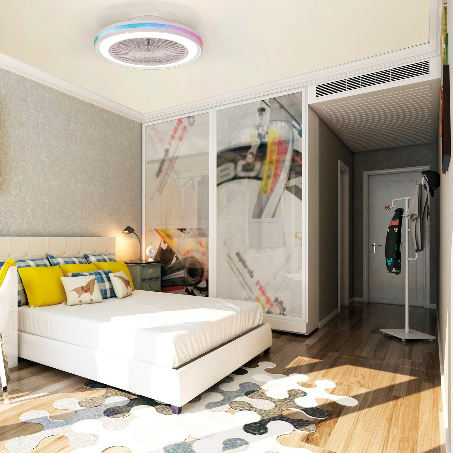 A modern bedroom with a white bed, yellow and gray pillows, and a nightstand with books and a lamp. A Ceiling Fans UK Gamer Large White RGB/CCT Ceiling Fan with lights—a 53cm 60W LED dimmable white/RGB ceiling light equipped with a built-in 26W DC reversible fan, complete with remote control—illuminates the room. Abstract artwork is displayed on glass doors, while a standing coat rack holds clothes. A geometric rug covers the wooden floor.