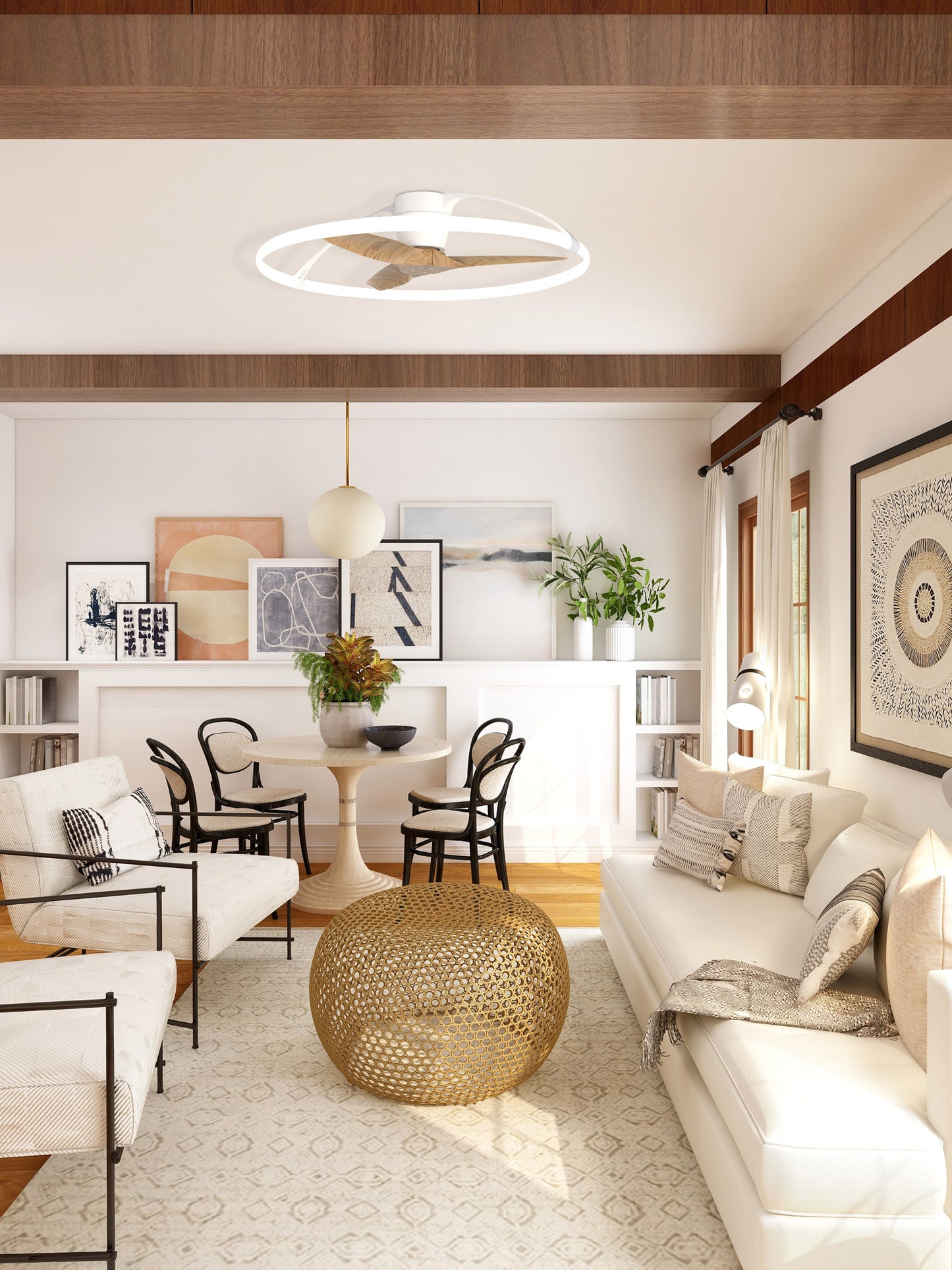 A contemporary living room with a beige and white color scheme features a Ceiling Fans UK's Nepal White/Beech Ceiling Fan with light 105cm, a built-in 35W DC Reversible Fan, modern artwork, a round dining table with black chairs, a white couch, and an intricate golden coffee table. Shelves with books and potted plants add a touch of greenery.