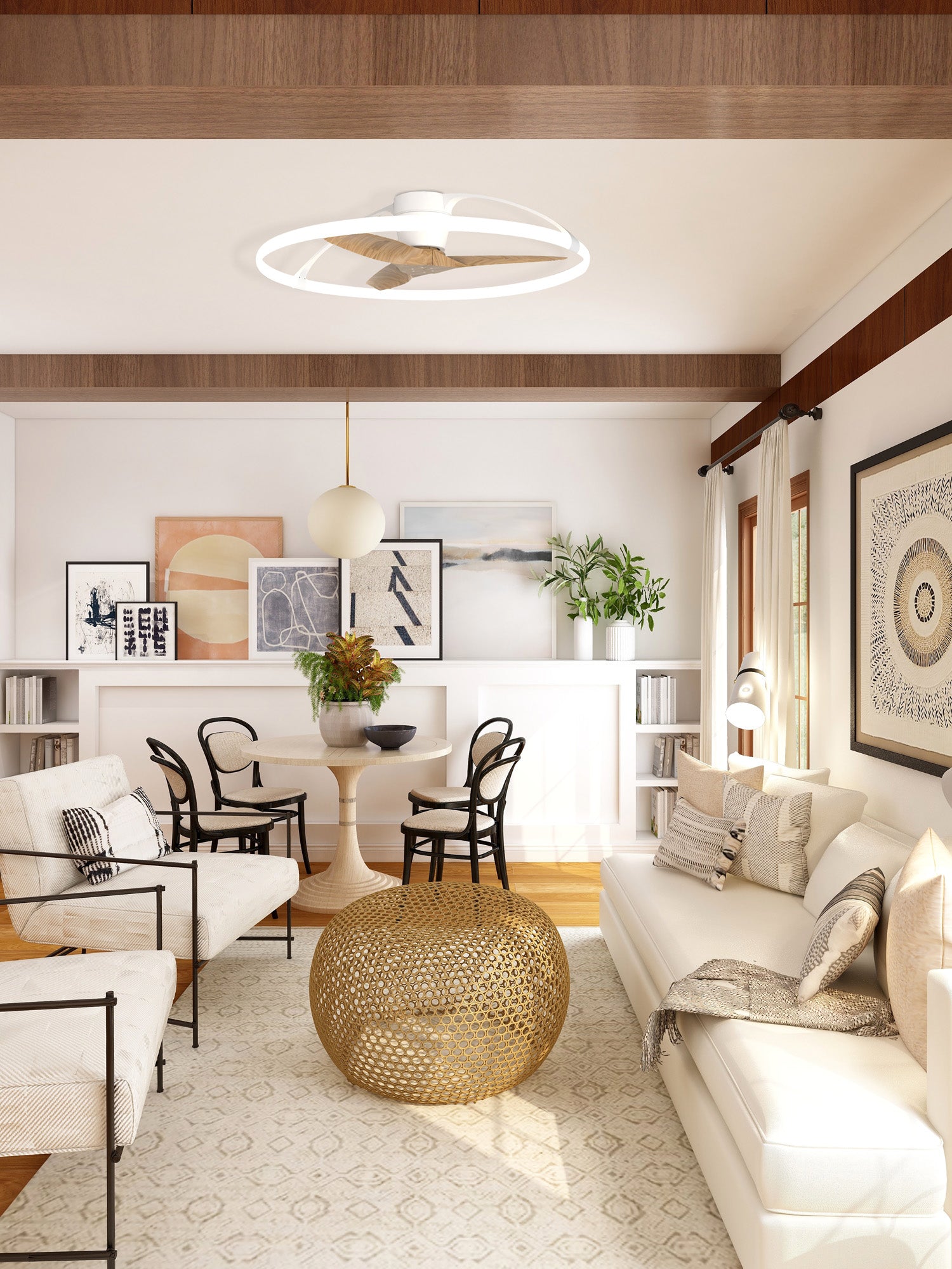 A contemporary living room with a beige and white color scheme features a Ceiling Fans UK's Nepal White/Beech Ceiling Fan with light 105cm, a built-in 35W DC Reversible Fan, modern artwork, a round dining table with black chairs, a white couch, and an intricate golden coffee table. Shelves with books and potted plants add a touch of greenery.