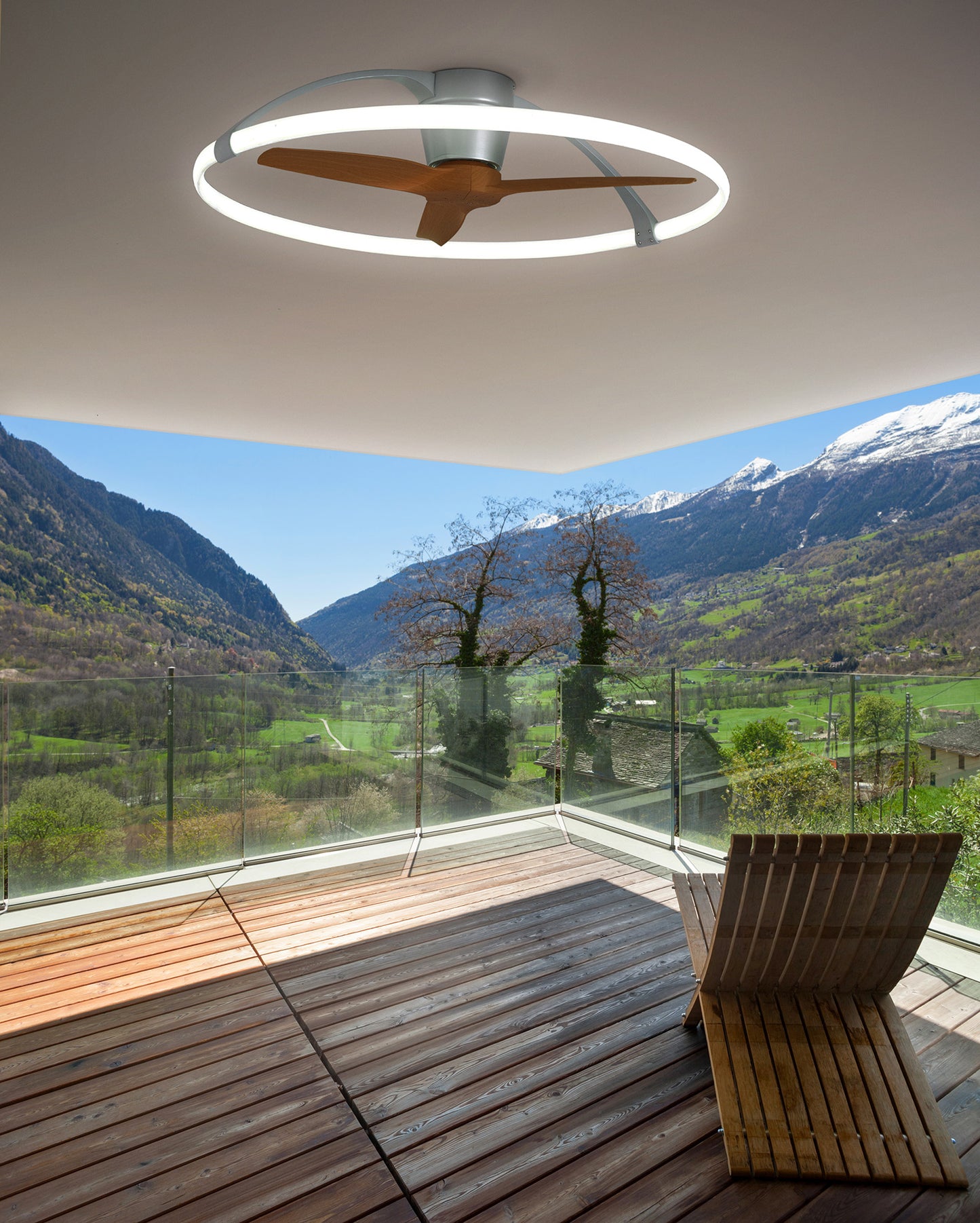 A MANTRA M7533 Nepal Silver/Walnut Ceiling Fan with 75W dimmable LED light from Ceiling Fans UK provides comfort on the wooden deck, its remote and smart controls circulating fresh air as you overlook a lush valley and mountains.