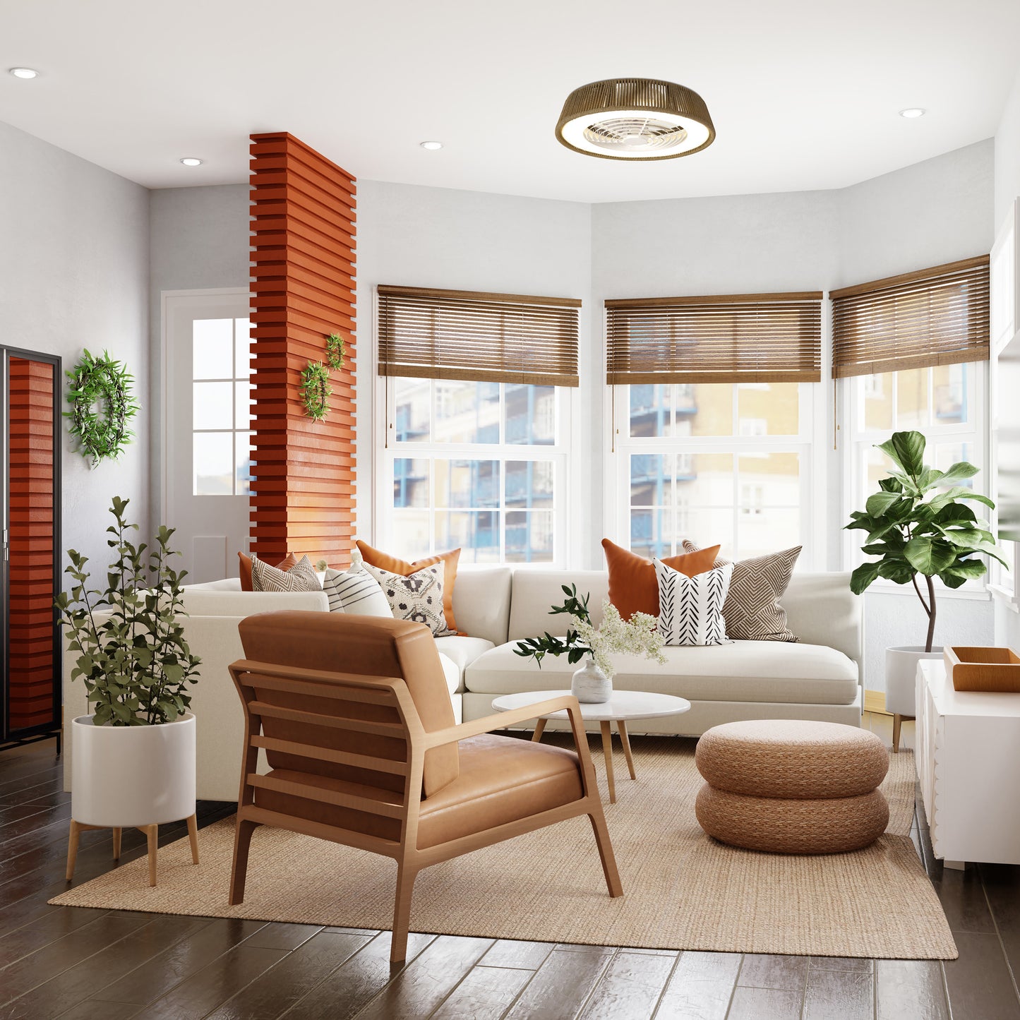 A modern living room features a white sofa, tan armchair, and round poufs. Large windows fitted with wooden blinds allow natural light to flood in, complemented by the Ceiling Fans UK Polinesia Nautic Beige Oscua ceiling fan, which includes a 70W LED dimmable light and a built-in 35W DC fan. Various plants enhance the decor, while a wooden accent wall contributes to the room's warm and welcoming atmosphere.